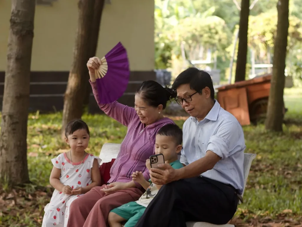 Gia đình ba thế hệ ngồi nghỉ trong công viên ở TP. Hồ Chí Minh